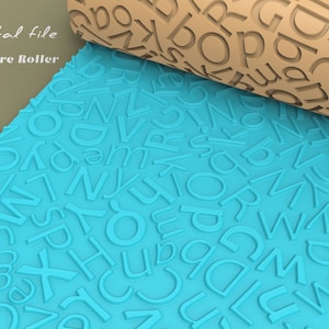 Puede incluir: Un rodillo de textura azul y beige con un patrón de letras en relieve. El rodillo está parcialmente desenrollado, revelando la superficie texturizada azul debajo.