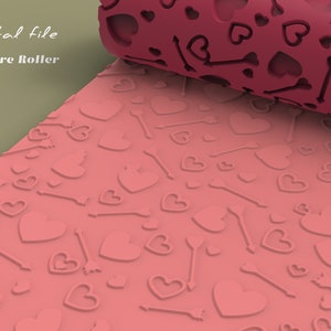 May include: A pink texture roller with a repeating pattern of hearts and arrows. The roller is designed for use with fondant, clay, or other craft materials. Digital file. Texture Roller.