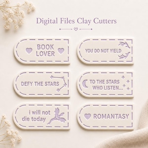 May include: Digital files of clay cutters in a soft, off-white color. Each cutter has a rounded rectangle shape with a dashed border and a cutout design. Text includes "BOOK LOVER", "YOU DO NOT YIELD", "DEFY THE STARS", "TO THE STARS WHO LISTEN...", "I WILL NOT DIE TODAY", and "ROMANTASY".