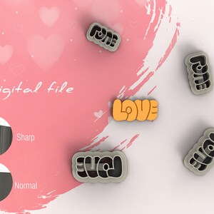 Può includere: Quattro stampini per biscotti su uno sfondo rosa e bianco. Gli stampini hanno la forma delle parole "LOVE", "FOREVER", "YOU" e "FOREVER". Lo stampino "LOVE" è arancione, e gli altri tre sono grigi.