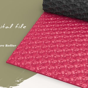 Op de afbeelding: Een rode textuurroller met een herhalend patroon van kleine schedels. De roller is gemaakt van een flexibel materiaal en is ontworpen om een ​​getextureerd effect op oppervlakken te creëren.