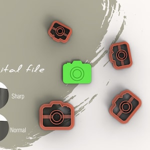 May include: Five camera-shaped cookie cutters, four are brown and one is green. The green camera cutter is in the centre of the image. The text "Digital file" is written in black cursive above the cutters. The text "Sharp" and "Normal" are written in black below the cutters.