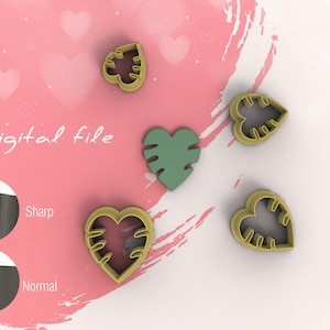 Puede incluir: Cuatro cortadores de galletas en forma de corazón con un diseño de hoja de monstera. Los cortadores son dorados, y uno es verde. El texto "Archivo digital" es visible en el fondo.