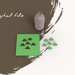 Könnte beinhalten: Eine digitale Datei für eine 3D-gedruckte Form. Die Form ist grün und hat ein Design aus sieben Hüten. Neben der Form befinden sich sieben einzelne grüne Hüte.