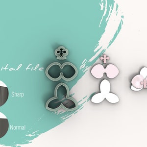 May include: A set of five cookie cutters in the shape of an orchid flower. The cutters are made of a light gray plastic and are arranged in a row. The cutters are designed to create a realistic orchid flower with a cross-shaped center and three petals.