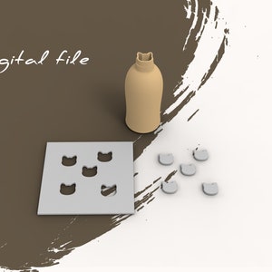Peut inclure: Un ensemble de moules en silicone pour faire des friandises en forme de chat. Les moules sont gris et de forme carrée. Il y a six moules en forme de chat au total. Les moules sont sur une surface blanche. Il y a aussi une bouteille brune avec un couvercle en forme de chat sur la surface.