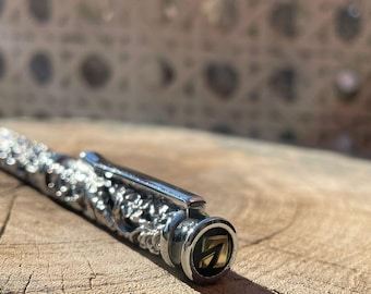 Bolígrafo plateado L’Azurde con cuerpo floral esculpido