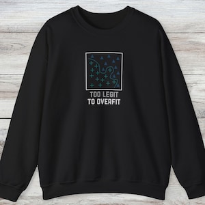 Puede incluir: Una sudadera negra de manga larga con un gráfico cuadrado blanco en el pecho. Dentro del cuadrado, una línea ondulada separa triángulos azules de signos más de color verde azulado. Debajo del gráfico, el texto dice TOO LEGIT TO OVERFIT en blanco.