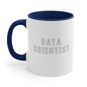 May include: White ceramic coffee mug with a blue rim and handle. The mug has the text "DATA SCIENTIST" printed in black outlined letters.