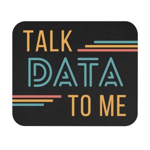 May include: Black mouse pad with the text "TALK DATA TO ME" in yellow, blue, and red. The text is stylized with lines and shapes.