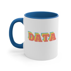 May include: White ceramic coffee mug with a blue rim. The mug has the word "DATA" printed on it in a rainbow-colored font.