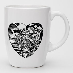 May include: White ceramic mug with a black and white illustration of two skeletons embracing in a heart shape. The skeletons are wearing floral crowns and are surrounded by palm trees and waves.