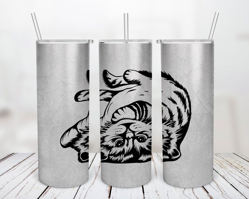 May include: Three stainless steel tumblers with a black and white graphic of a cat curled up on its back. The tumblers are silver with a brushed finish.
