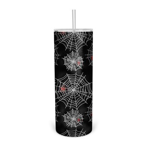 May include: A black and white tumbler with a spiderweb pattern and red spiders. The tumbler has a clear lid and a straw.