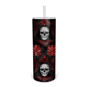 May include: A black and red tumbler with a skull and floral pattern. The tumbler has a clear lid and a straw.