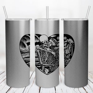 May include: Three silver stainless steel tumblers with a black and white graphic of two skeletons kissing inside a heart shape. The graphic also includes palm trees and a moon.