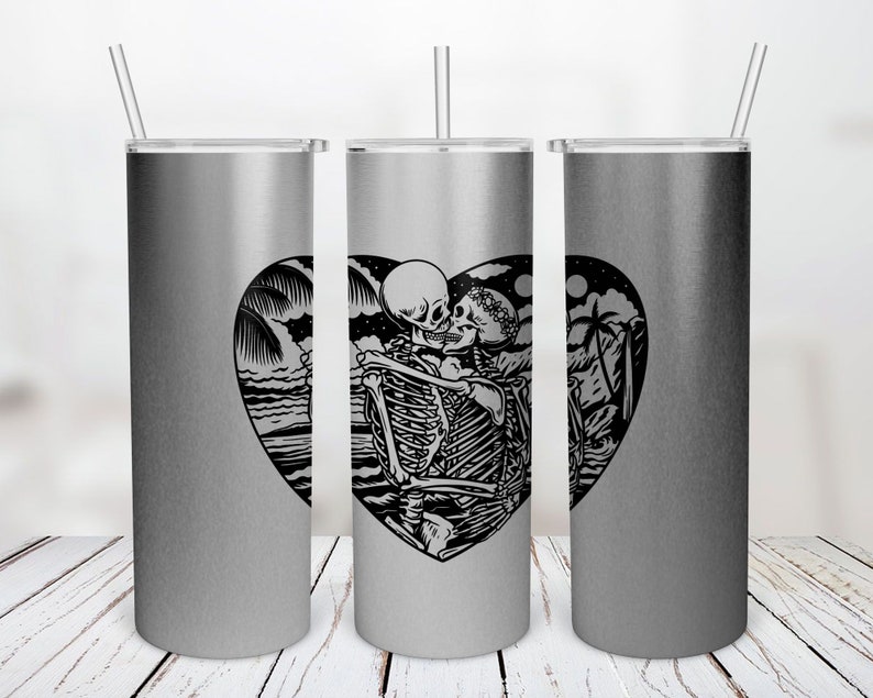 May include: Three silver stainless steel tumblers with a black and white graphic of two skeletons kissing inside a heart shape. The graphic also includes palm trees and a moon.