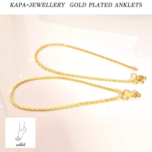 May include: Two gold-plated anklets with a delicate chain design and a small, ornate clasp. KAPA-JEWELLERY GOLD PLATED ANKLETS is written at the top of the image.