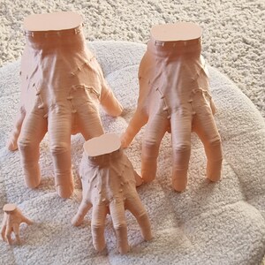 Op de afbeelding: Vier verschillende maten, vleeskleurige, 3D-geprinte handen met gedetailleerde vinger- en knokkeltexturen.