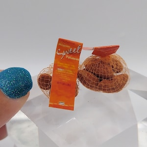 May include: A miniature bag of sweet potatoes with a bright orange label that reads "Premium Sweet Potatoes".