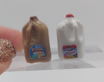May include: Two miniature plastic milk cartons, one brown and one white. The brown carton has a TruMoo chocolate milk label. The white carton has a Great Value whole milk label.