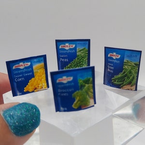 May include: Four different Birds Eye Steamfresh frozen vegetable packages. The packages are blue and white with pictures of the vegetables. The vegetables are peas, green beans, corn, and broccoli florets.