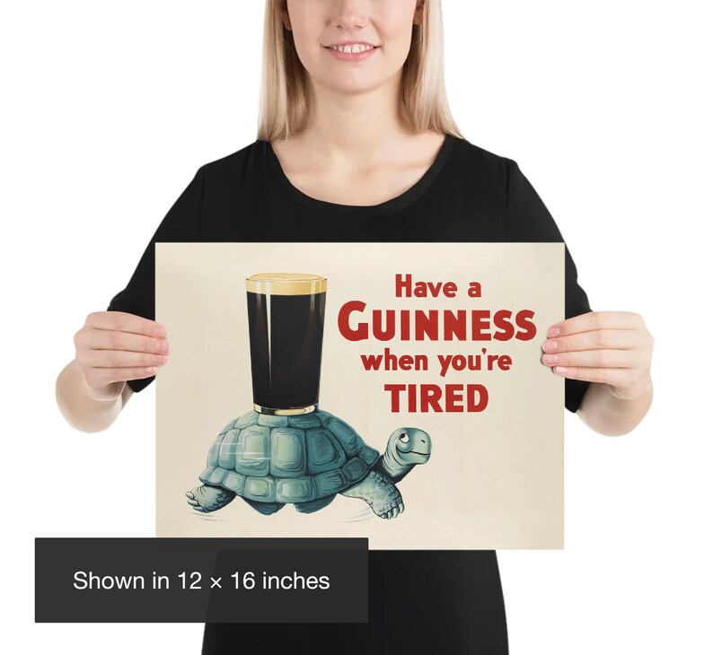 K&ouml;nnte beinhalten: Ein Poster mit dem Text "Have a Guinness when you're TIRED". Das Bild zeigt ein Pint Guinness, das auf einer blauen Schildkr&ouml;te balanciert. Das Poster wird in 30,48 x 40,64 cm angezeigt.
