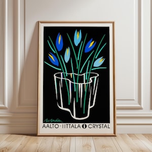 Könnte beinhalten: Gerahmter Kunstdruck mit stilisierten blauen Blumen in einer weißen Vase vor schwarzem Hintergrund. Der Druck enthält den Text "AALTO • IITTALA • CRYSTAL". Das Kunstwerk ist in einem Holzrahmen.