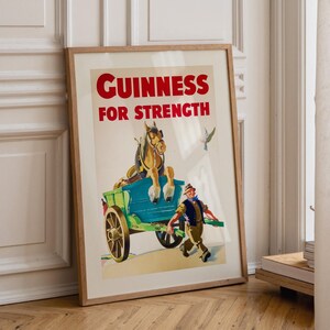 K&ouml;nnte beinhalten: Gerahmtes Vintage-Guinness-Werbeplakat. Das Poster zeigt einen Pferdewagen mit einem Mann, der daneben herl&auml;uft. Der Text "GUINNESS FOR STRENGTH" ist rot. Das Kunstwerk hat einen Vintage-Illustrationsstil.