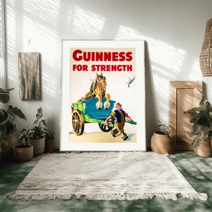 K&ouml;nnte beinhalten: Gerahmtes Vintage-Guinness-Werbeplakat. Das Poster zeigt ein Pferd, das einen Wagen zieht, mit einem Mann, der daneben rennt. Der Text "GUINNESS FOR STRENGTH" ist rot. Das Poster steht vor einer wei&szlig;en Wand.