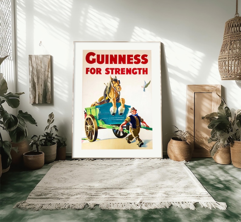 K&ouml;nnte beinhalten: Gerahmtes Vintage-Guinness-Werbeplakat. Das Poster zeigt ein Pferd, das einen Wagen zieht, mit einem Mann, der daneben rennt. Der Text "GUINNESS FOR STRENGTH" ist rot. Das Poster steht vor einer wei&szlig;en Wand.