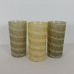 May include: Three vintage drinking glasses with a textured, woven pattern. The glasses are in shades of green and brown.