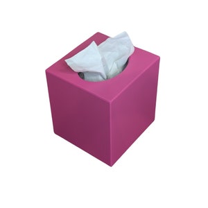 May include: A pink square tissue box with a white tissue peeking out of the opening.