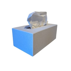 May include: A white tissue box with a white tissue pulled out of the top opening. The box is made of a textured material and is light gray in color.