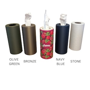May include: Five tissue box holders in different colours: olive green, bronze, red with a pomegranate pattern, navy blue, and stone. The tissue box holders are all cylindrical and have a simple design.