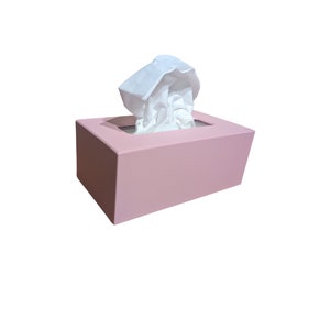 May include: A pink tissue box with a white tissue pulled out of the opening.