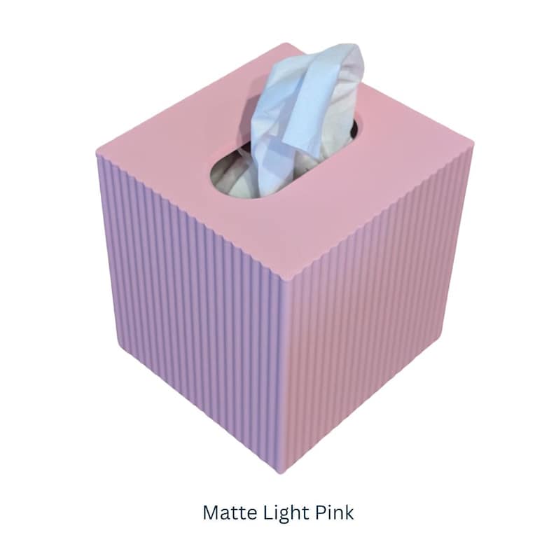 May include: Matte light pink tissue box cover with a ribbed texture. The cover has a slot for tissues to be pulled out.