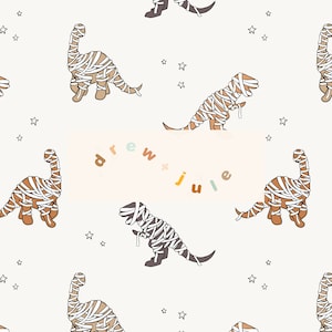 May include: A seamless pattern featuring mummified dinosaurs with white bandages and brown bodies against a white background with small white stars. The text "drew + julie" is in the center of the pattern in colorful letters.