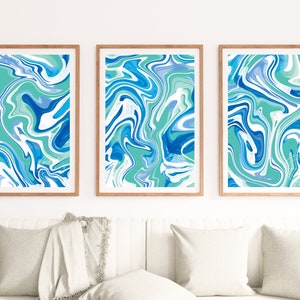 Pu&ograve; includere: Tre stampe d'arte astratta incorniciate con un motivo a marmi blu, verde e bianco vorticoso.