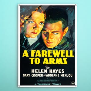 Op de afbeelding: Een vintage filmposter voor de film "A Farewell to Arms" met Helen Hayes, Gary Cooper en Adolphe Menjou. De poster heeft een geel en zwart kleurenschema met een donkere achtergrond.