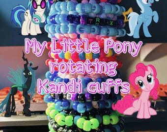 May include: A vertical stack of colorful plastic pony bead bracelets featuring letter beads that spell out names and phrases. The bracelets are decorated with My Little Pony character illustrations and star-shaped charms. The text My Little Pony rotating Kandi cuffs is overlaid on the image.