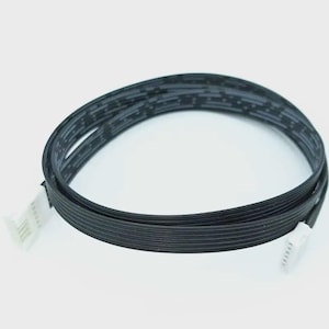 May include: A black ribbon cable with white connectors at each end. The cable is looped and appears to be made of multiple thin, flat wires. The connectors have multiple pins.