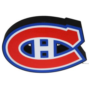 May include: A black, red, white, and blue Montreal Canadiens logo. The logo is in the shape of a large letter "C" with a smaller "H" inside. The logo is a light-up sign.