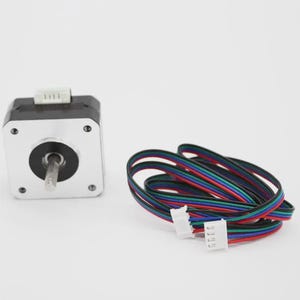 Pode incluir: Um motor de passo com corpo prateado e preto, um eixo saliente e um conector branco. Um feixe de fios multicoloridos com conectores brancos também está presente. Os fios são pretos, vermelhos, azuis e verdes.