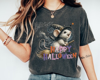 May include: A dark gray t-shirt with a graphic of a cute mouse wearing a witch hat and riding a broomstick. The text "Happy Halloween" is printed in colorful letters below the mouse.
