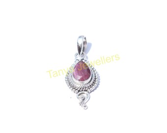 May include: A silver pendant featuring a pink gemstone in a teardrop shape. The pendant is adorned with intricate silver detailing around the gemstone and a dangling silver charm.