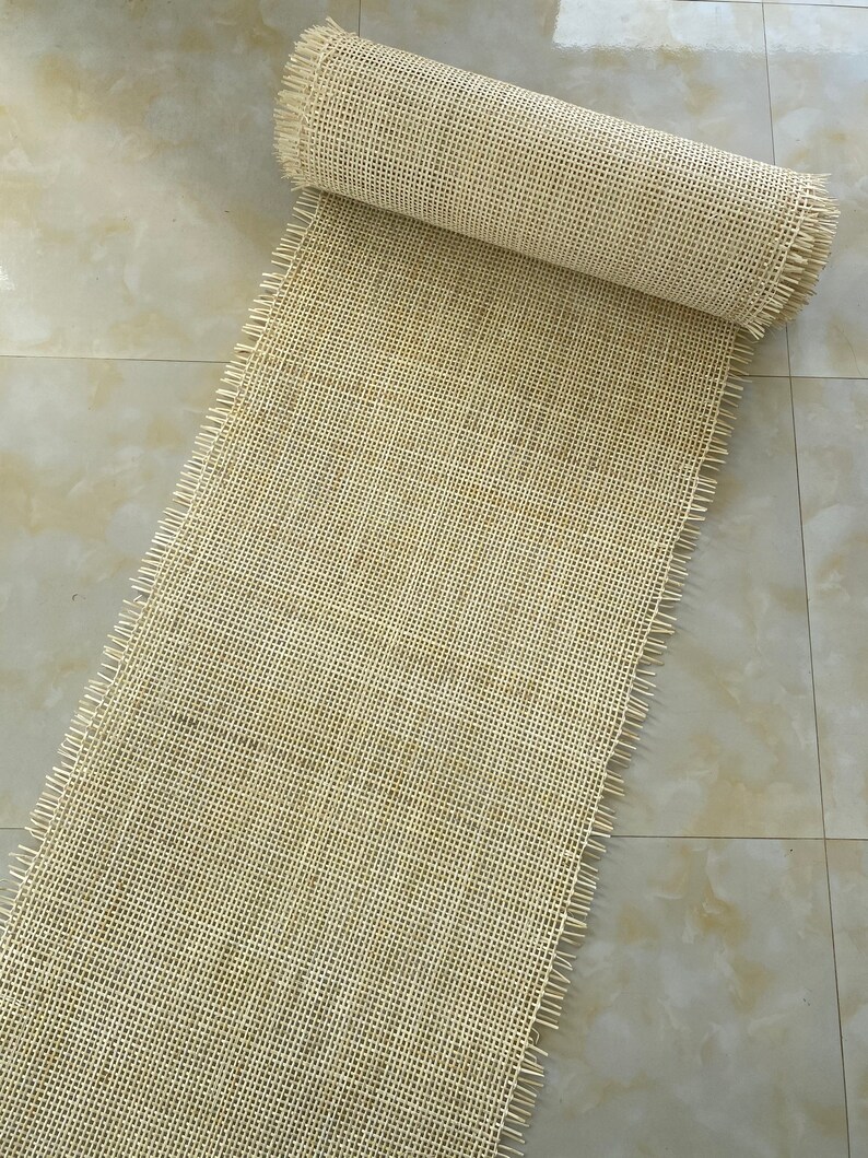Pode incluir: Um rolo de tecido natural bege, tecido, franjado, com um padr&atilde;o de grade.