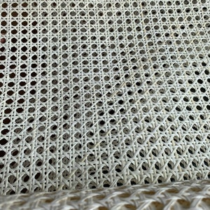 K&ouml;nnte beinhalten: Wei&szlig;es Rohrgeflecht, ein gewebtes Material, das f&uuml;r Sitzfl&auml;chen und R&uuml;ckenlehnen von St&uuml;hlen verwendet wird. Das Geflecht besteht aus einem dicht gewebten, flexiblen Material, das strapazierf&auml;hig und bequem ist.