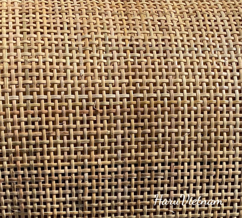 May include: Close-up of a woven cane material with a natural brown color. The material is woven in a tight, even pattern, creating a smooth, textured surface. The text "Haru Vietnam" is visible in the lower right corner of the image.