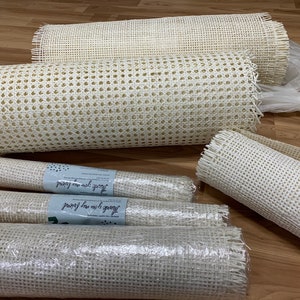 May include: Five rolls of white cane webbing, a material used for chair caning and other crafts. The rolls are wrapped in clear plastic and labelled "Thank you for your order".